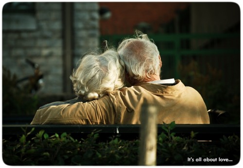 An elderly couple, sitting, in love