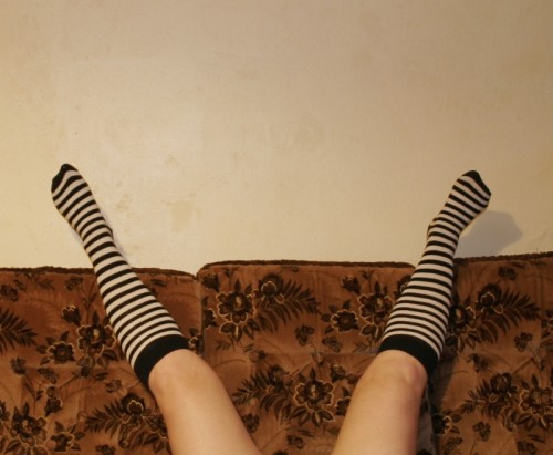 Legs spread wide open, on a couch