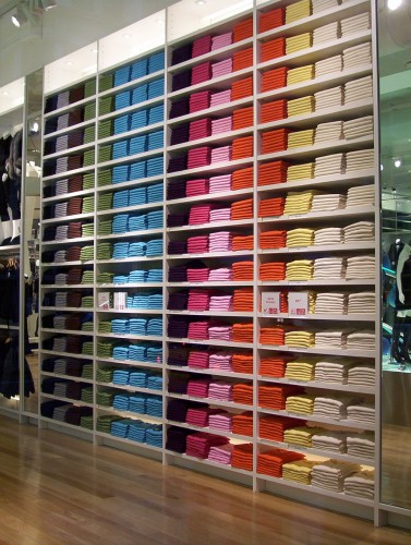 Shelves of different colored outfits.