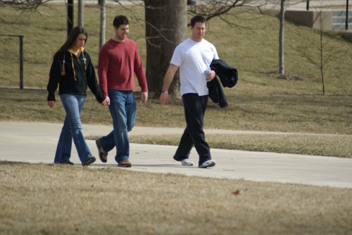 The third wheel A couple, walking with a third wheel in tow.